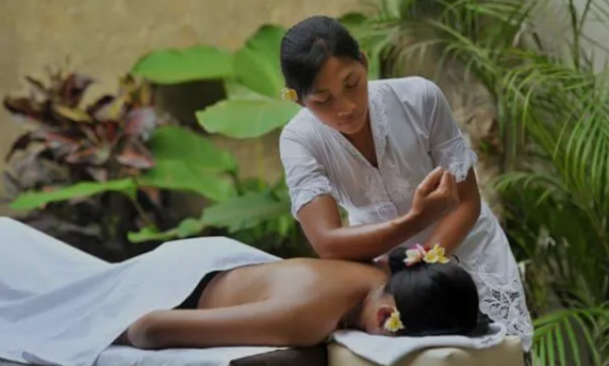 Traditional Balinese massage therapist working on back in West Coast Mauritius