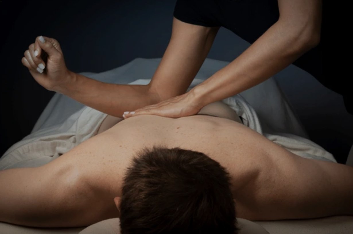 Deep tissue massage therapist using forearm pressure on back in West Coast Mauritius